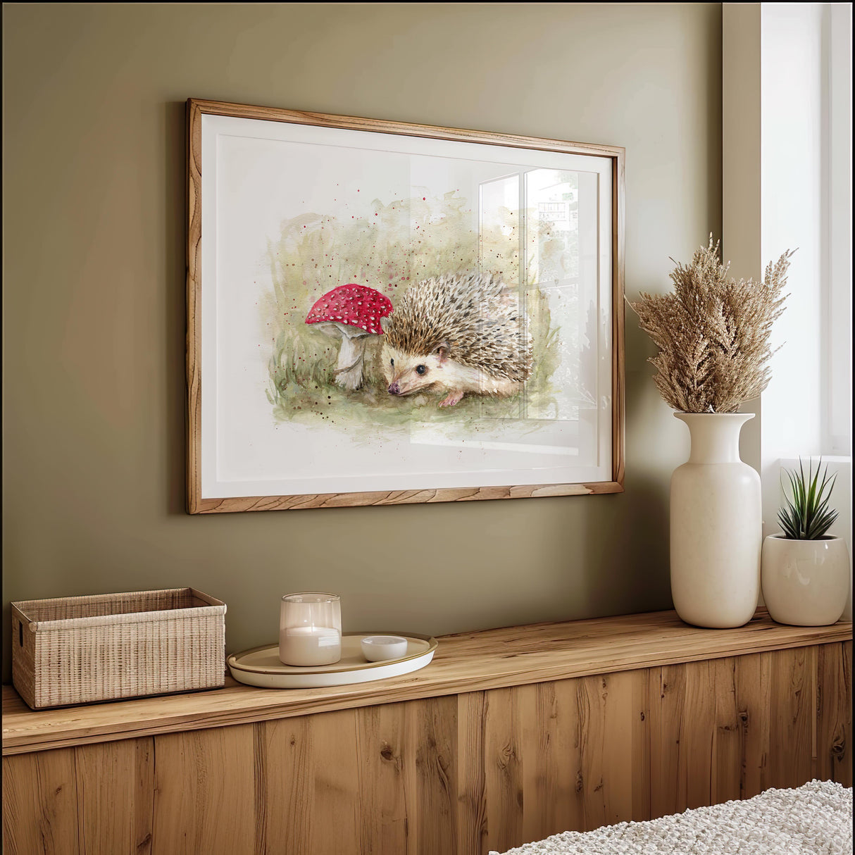Watercolour painting of a hedgehog beside a red toadstool in a soft woodland setting, evoking calm and curiosity.
