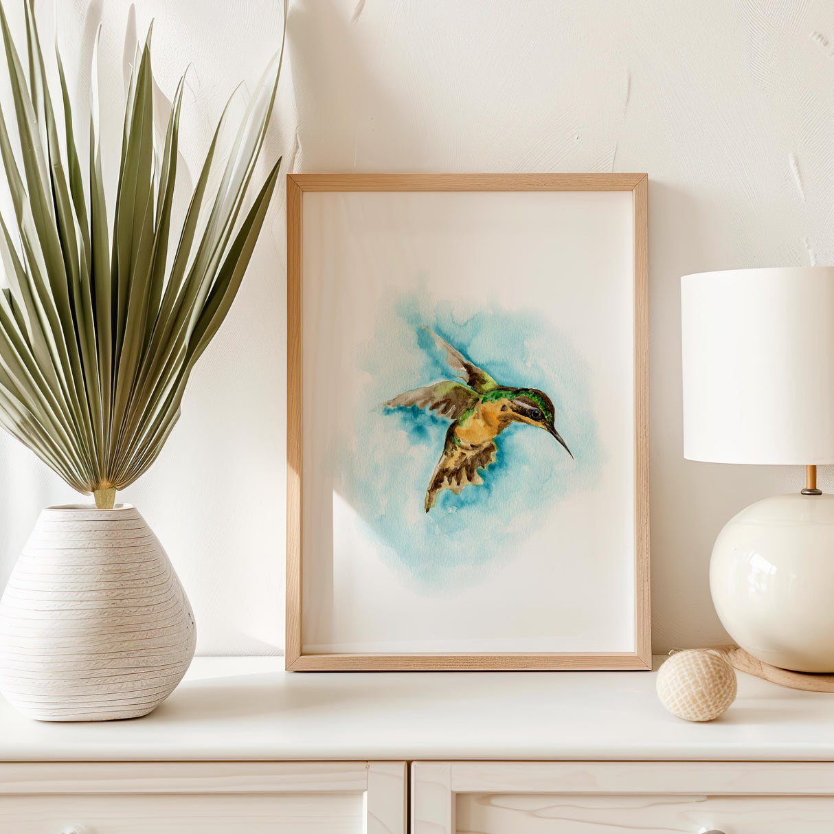 Watercolor hummingbird print featuring a green and brown bird flying through turquoise sky.