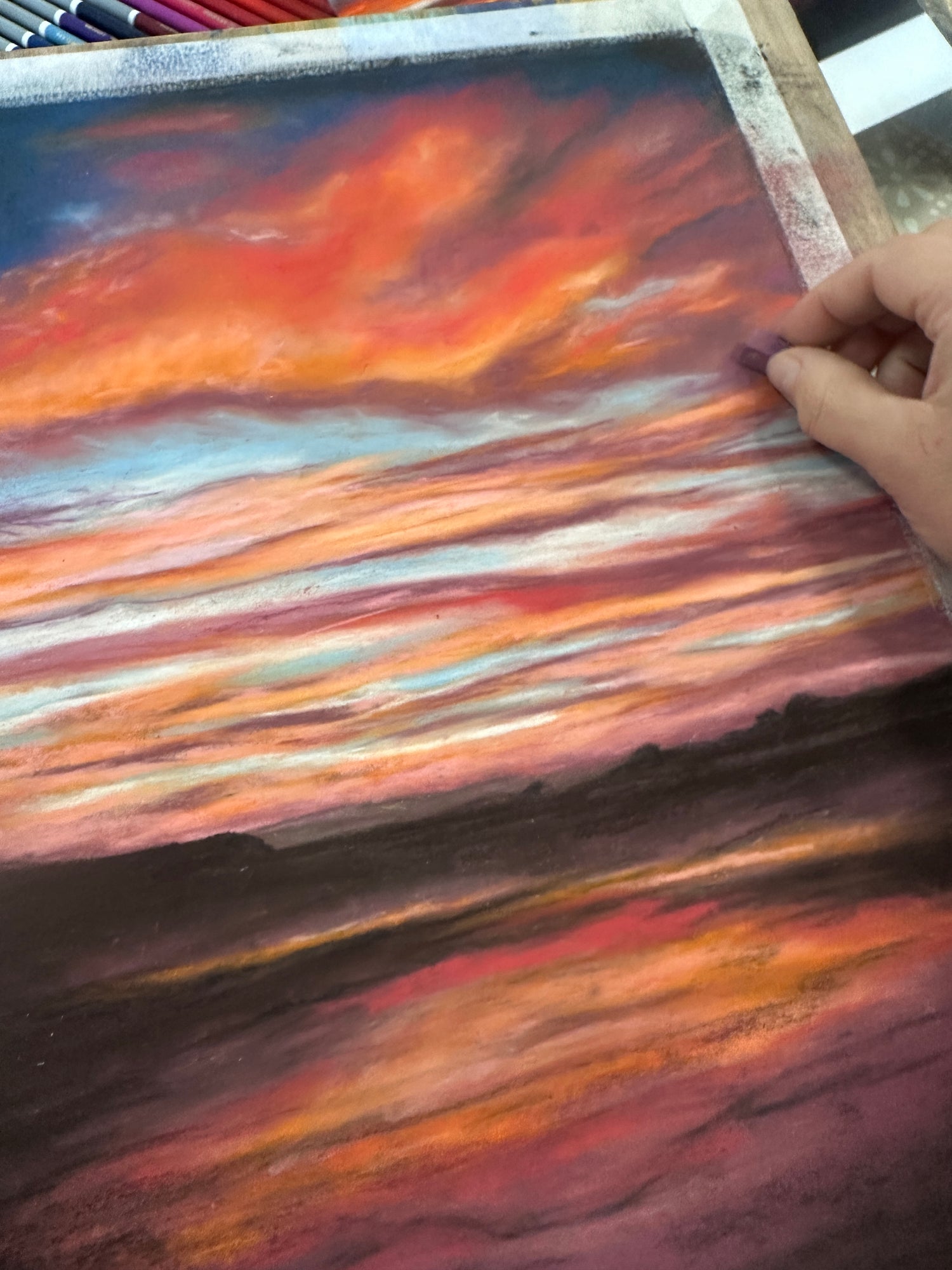 Vibrant seascape painting with a glowing sunset over the British coastline, created using pastels.