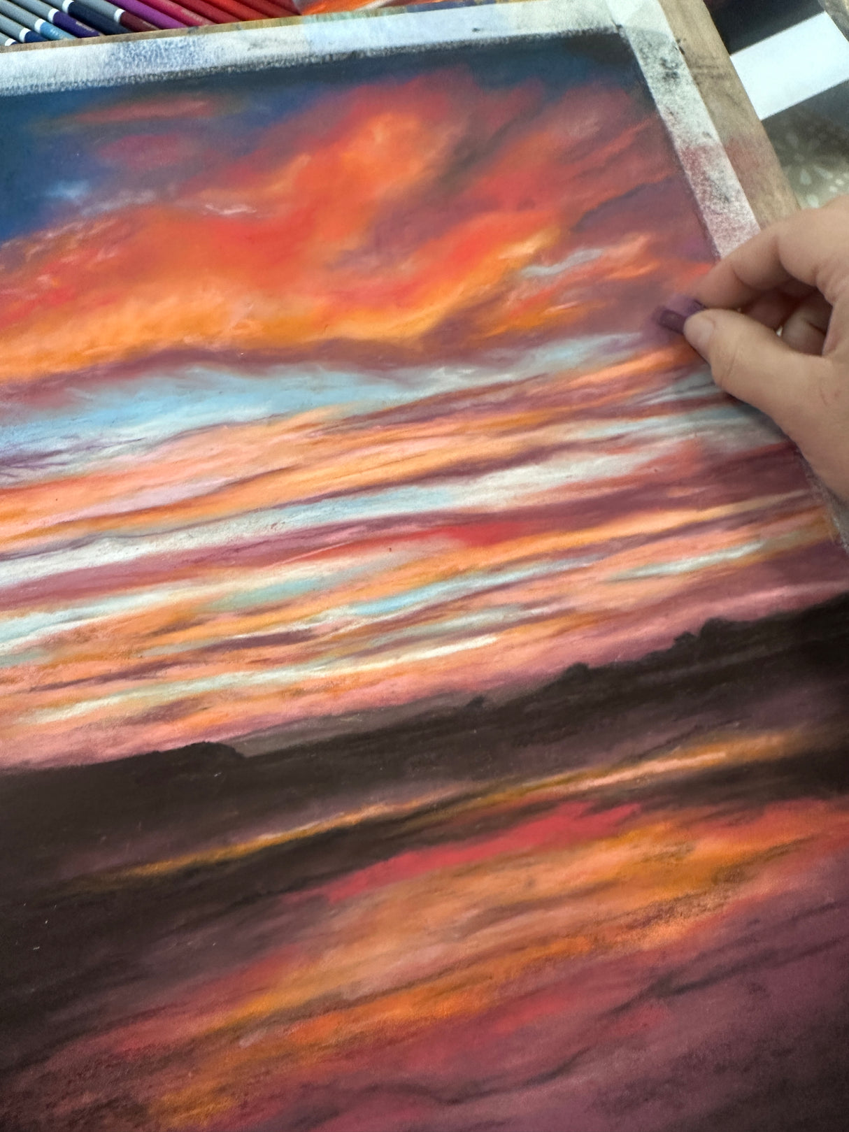 Vibrant seascape painting with a glowing sunset over the British coastline, created using pastels.