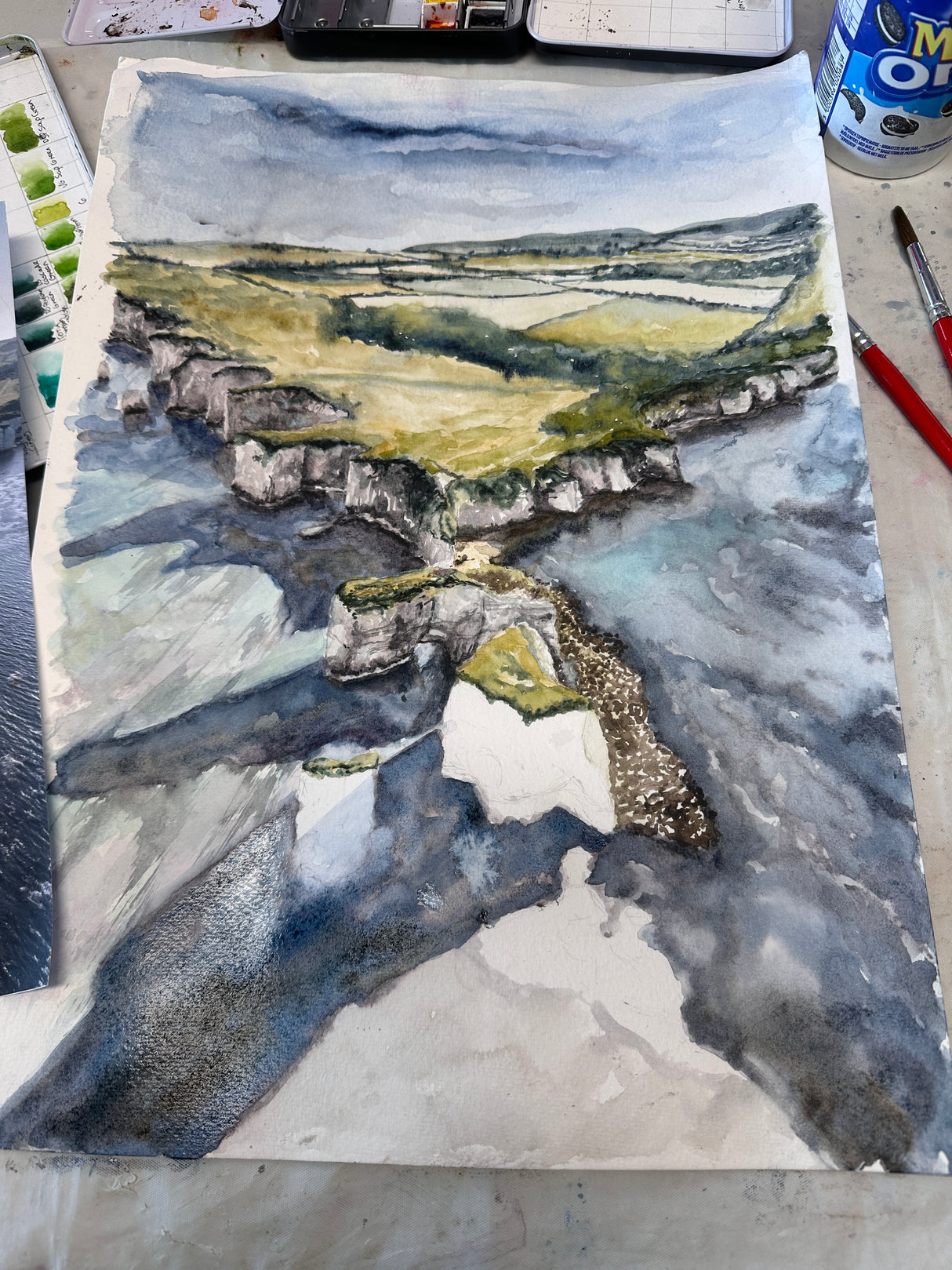 Seaside painting with white rocks and rolling hills