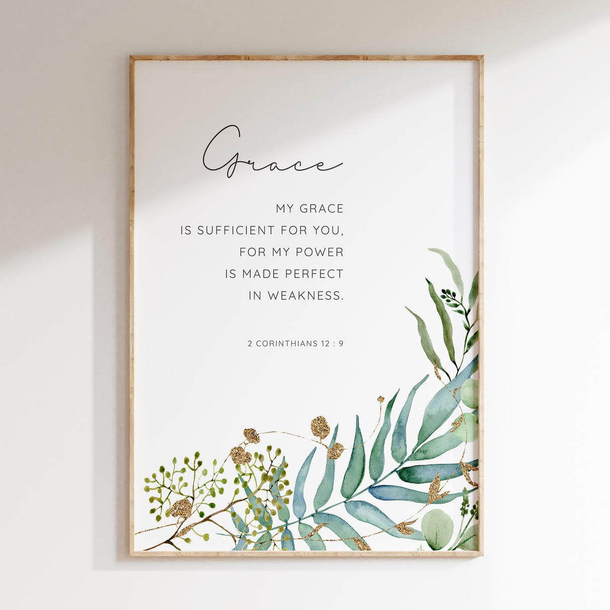 Inspiring Christian decor with 2 Corinthians 12:9 and delicate green foliage.