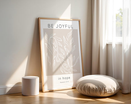 Minimalist Christian home decor print with calming design and "Be joyful in hope" calligraphy. Encouraging Romans 12:12 scripture wall art in beige and white for modern, faith-filled living spaces.

