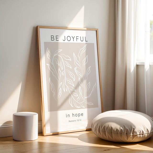 Minimalist Christian home decor print with calming design and "Be joyful in hope" calligraphy. Encouraging Romans 12:12 scripture wall art in beige and white for modern, faith-filled living spaces.

