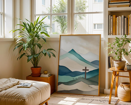 Faith-inspired Easter print of a brown cross set against majestic blue and green mountains with the scripture “He Has Risen” at the base.