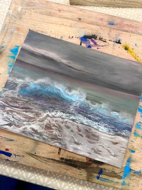 A detailed wave painting showing the glow of light on water.