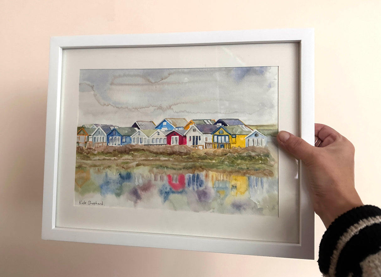 Dorset beach huts painting in vibrant watercolor, framed with cream mount.