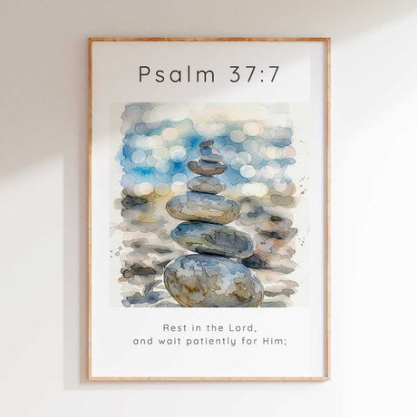 Psalm 37:7 - Rest In The Lord scripture wall art print with watercolour stacked pebbles and soft blue bokeh background.
