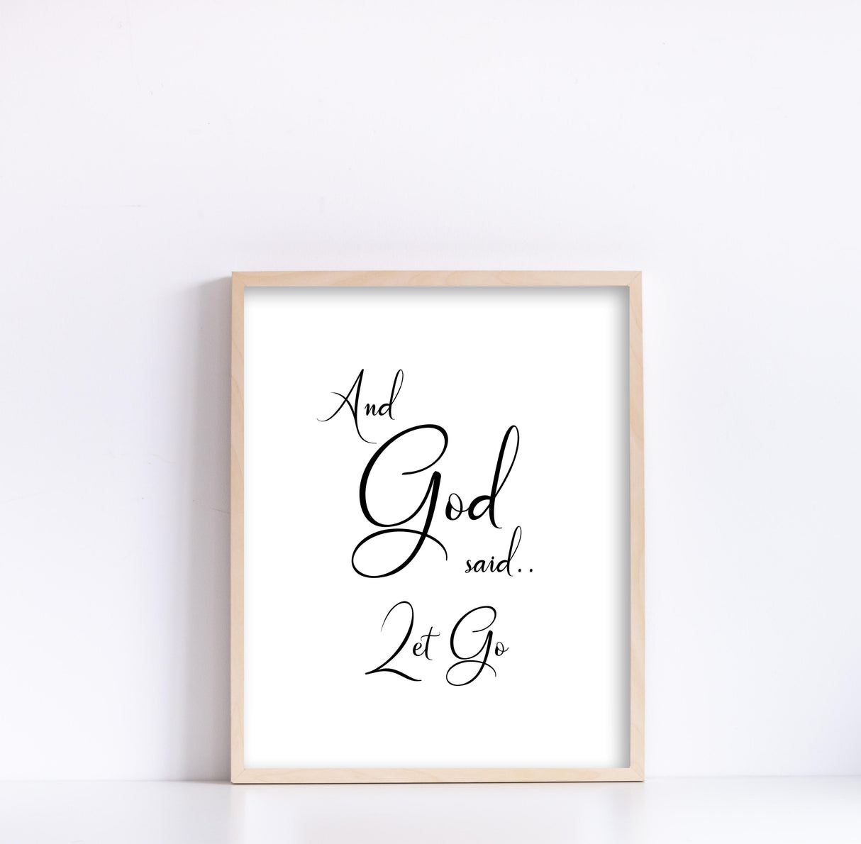 Minimalist Christian print in black and white with swirly writing of 'And God Said Let Go'.